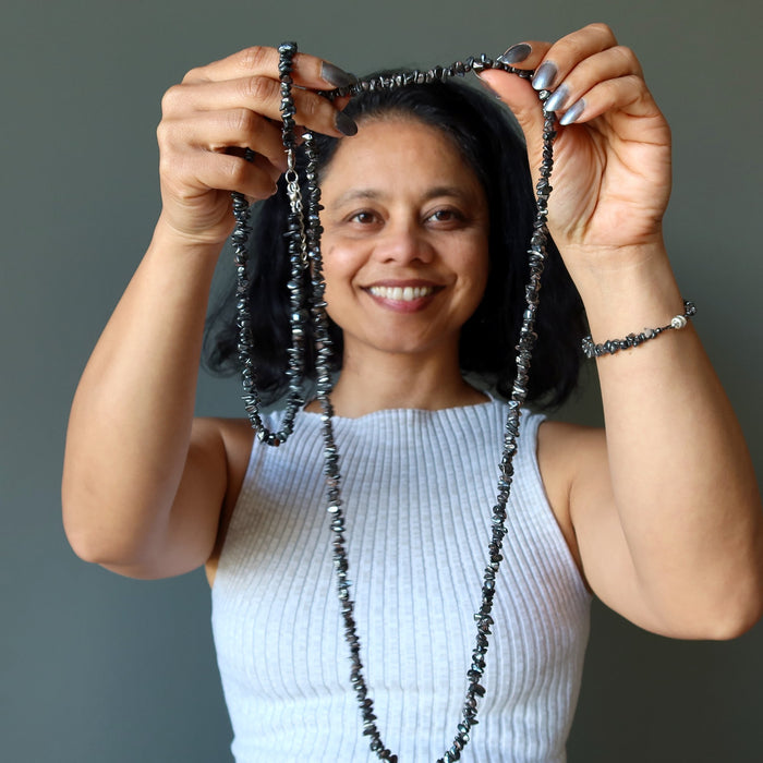 woman holding two hematite necklaces