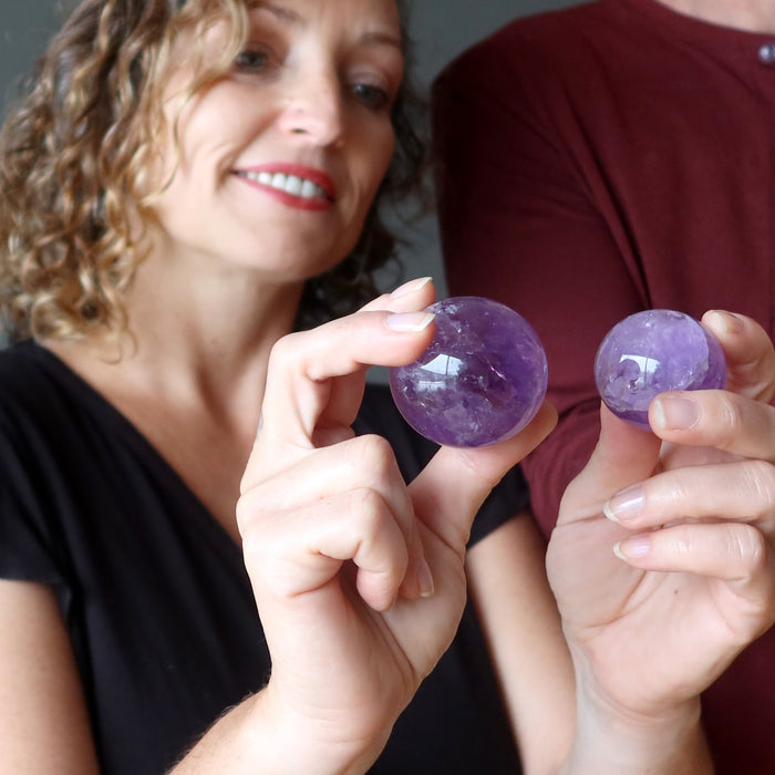 Alex of satin crystals holding an amethyst ball on each hand