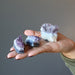 hand holding amethyst geode clusters