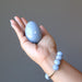 hand holding angelite egg wearing angelite bracelet