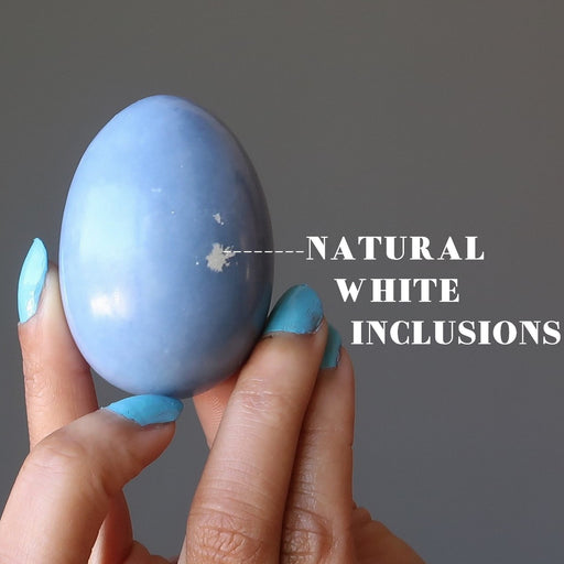 hand holding angelite egg showing natural white inclusions