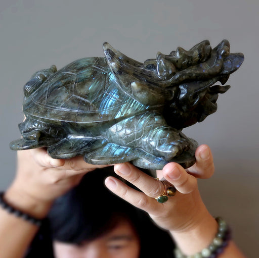 lydia of satin crystals holding a big labradorite dragon turtle carving over her head