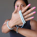 sheila of satin crystals wearing and showing off beaded aquamarine bracelets and necklace