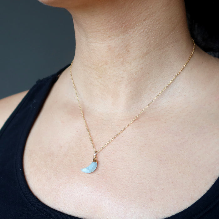 aquamarine crescent moon pendant on gold necklace on female neck