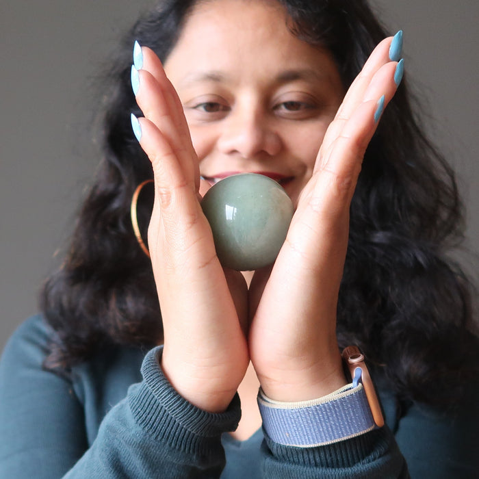 sheila of satin crystals holding a green aventurine crystal ball in between hands