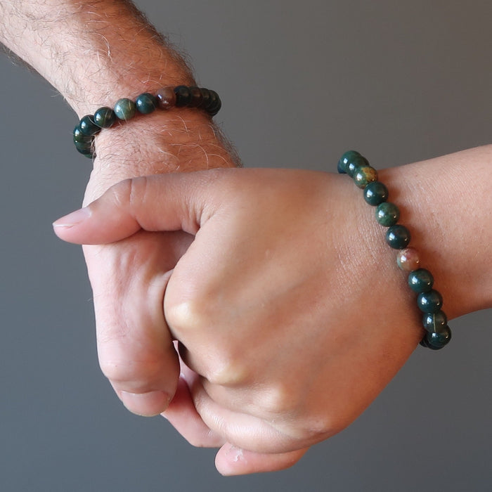 man and woman holding hands both wearing bloodstone bracelets