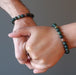 man and woman holding hands both wearing bloodstone bracelets