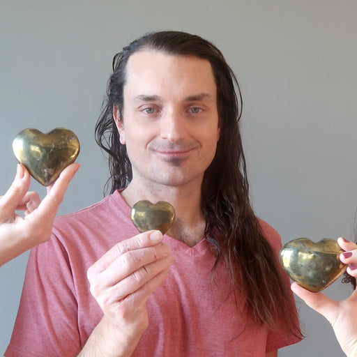male model and two other hands each holding gold Chalcopyrite Heart 