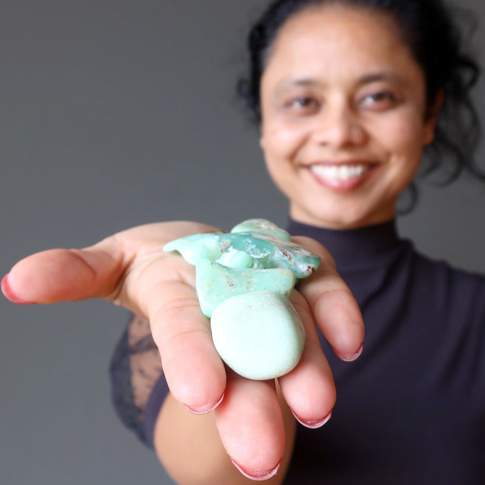 sheila of satin crystals holding two chrysoprase tumbled stones