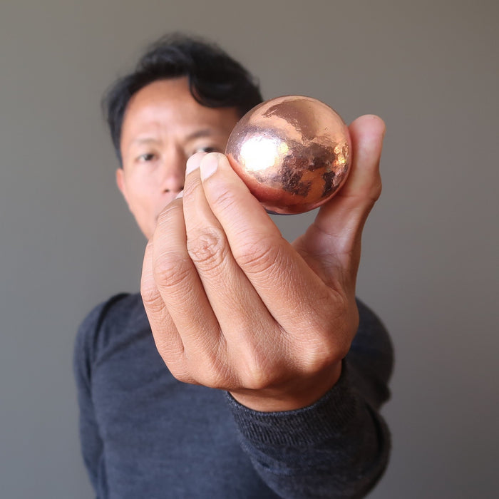 tim of satin crystals holding a copper alchemist sphere