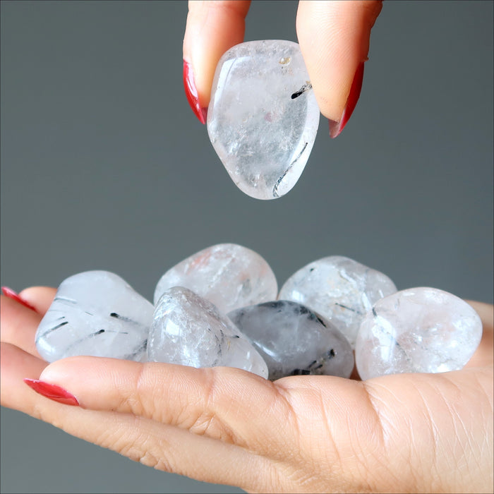 tourmalinated quartz tumbled stones in hands