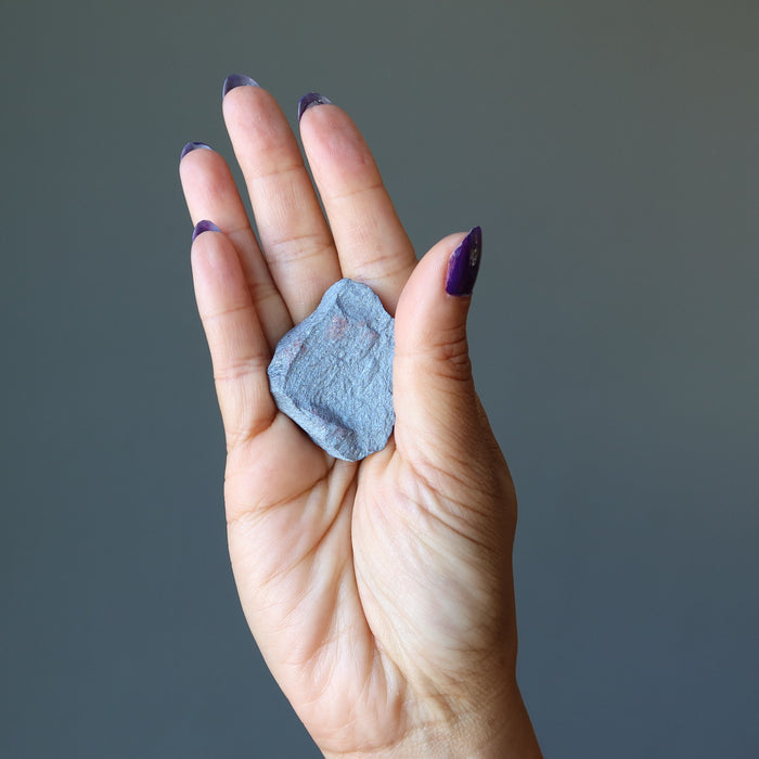 raw hematite stone in palm of hand
