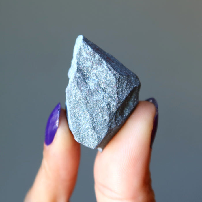 hand holding raw hematite stone