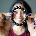 sheila of satin crystals holding up hypersthene bracelet