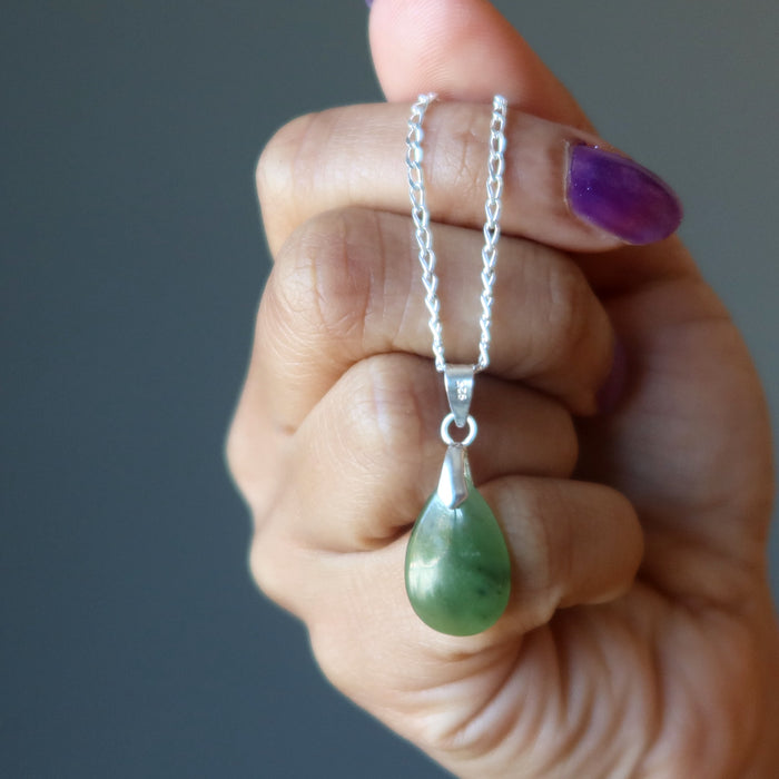 hand holding jade pendant on sterling silver chain