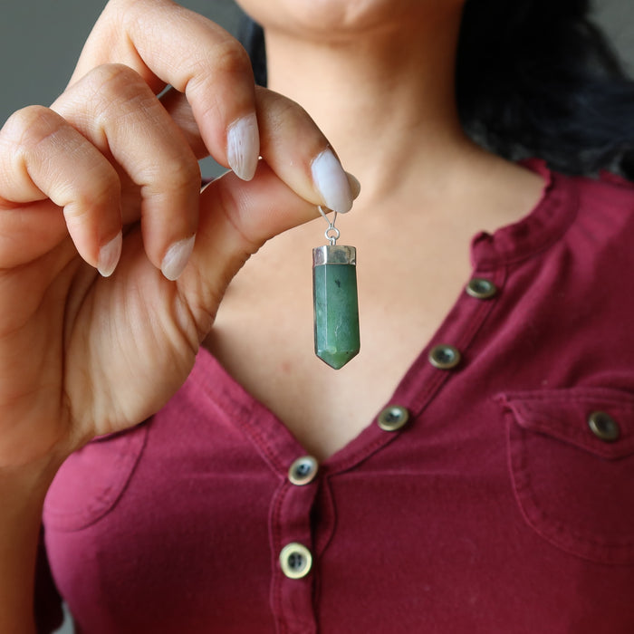 woman holding jade faceted point pendant at chest
