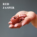 hand holding red jasper tumbled stones