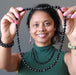 sheila of satin crystals holding up a black jet stone beaded necklace