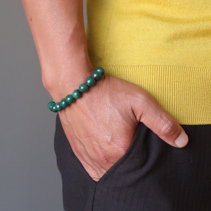 man's hand in pants pocket wearing green malachite stretch bracelet
