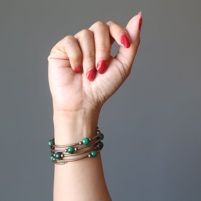A woman's hand and arm showing off the Malachite vintage coil bracelet