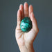 hand holding up a malachite egg