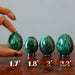 four malachite eggs on ring stands showing size difference