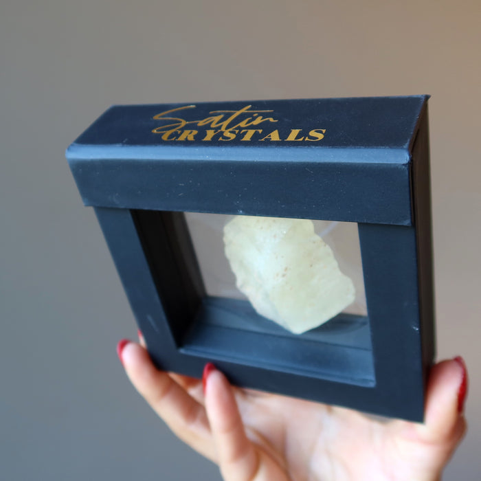 hand holding libyan desert glass in a floating case