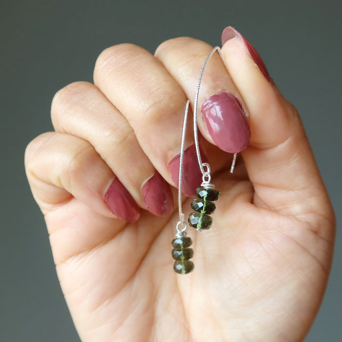 hand holding moldavite earrings