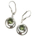 faceted green moldavite and red garnets in circular sterling silver earring