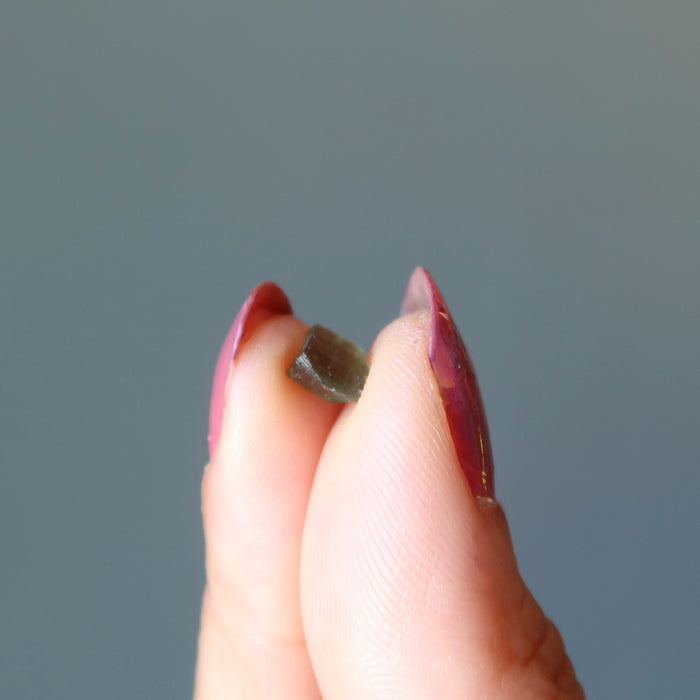 hand holding tiny xs raw moldavite