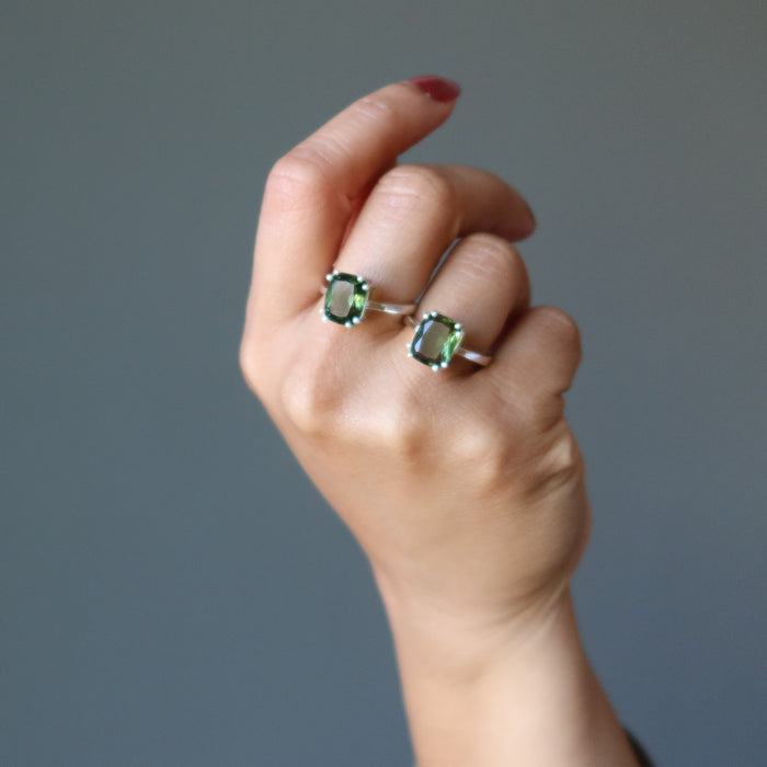 hand wearing 2 moldavite ring on fingers