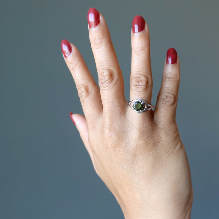 hand wearing a moldavite faceted ring on the finger
