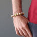 man's hand in pants pocket wearing yellow peach moonstone round stretch bracelet