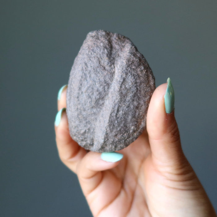 hand holding a natural moqui stone