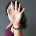 sheila of satin crystals holding a hand up wearing a matte and polished glossy beaded round black onyx stretch bracelet