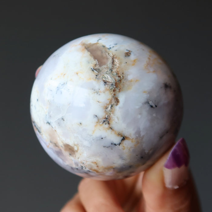 hand holding white opal sphere