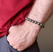 mans hand in pocket wearing round pyrite beaded stretch bracelet