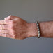 mans hand wearing round pyrite beaded stretch bracelet