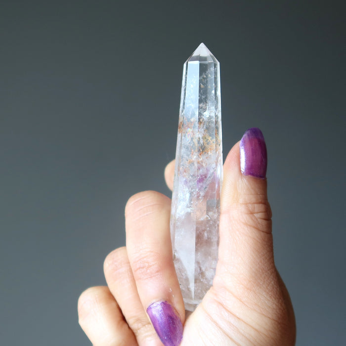 holding faceted Clear Quartz Wand Tower