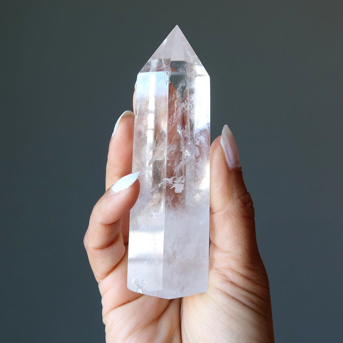 holding faceted Clear Quartz Wand Tower