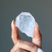 holding one raw clear quartz point