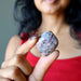 Sheila Satin of Satin Crystals is holding rhodonite cabochon