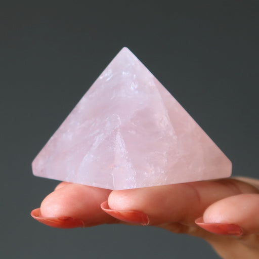 hand holding pink rose quartz pyramid
