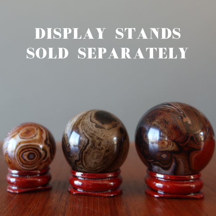 three sardonyx spheres on wood display stands, which are sold separately