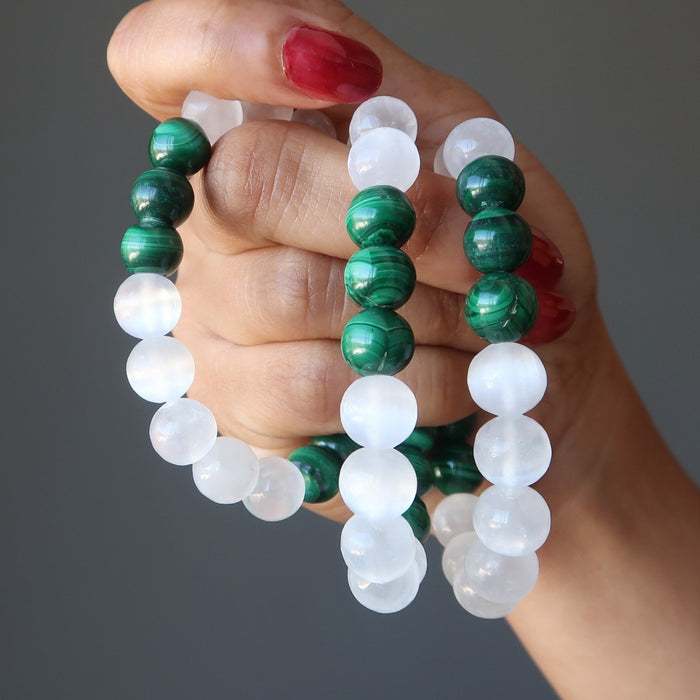 three green malachite and white selenite bead bracelets being held in the hand of lady
