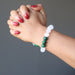 White selenite and green malachite round beaded bracelet on a hand model 