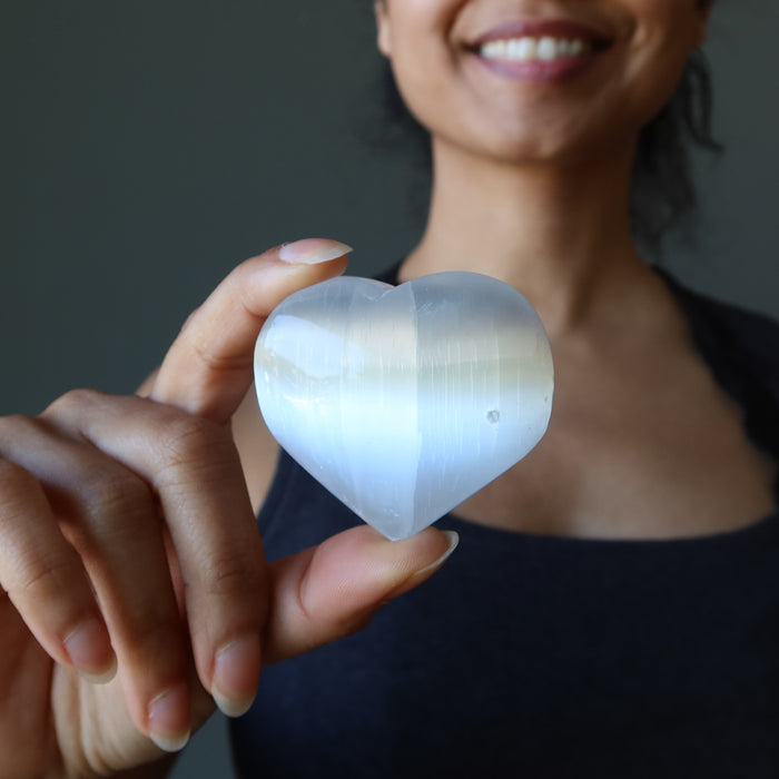 sheila of satin crystals holding a white selenite heart