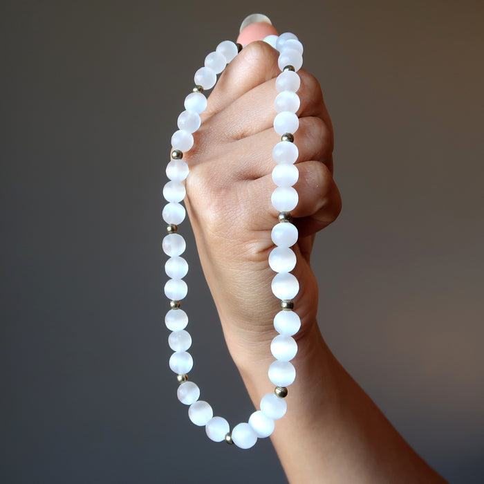 hand holding white selenite necklace