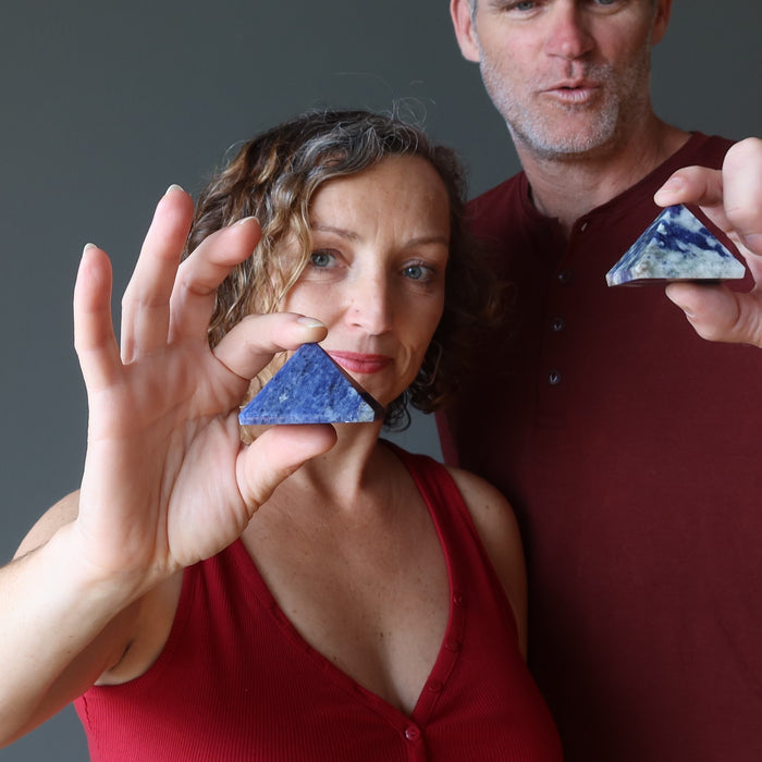 couple holding sodalite pyramids