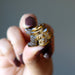 finger tips holding one tigers Eye dragon statue